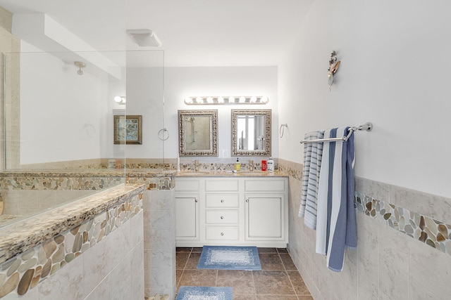 bathroom with tile patterned floors, vanity, and tile walls