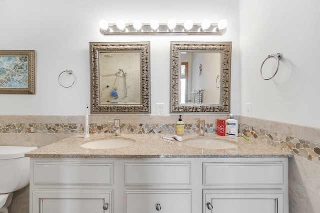 bathroom featuring vanity, toilet, and tile walls