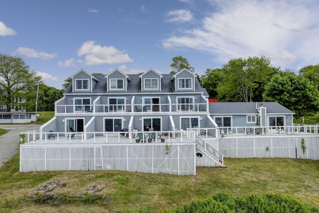 rear view of property featuring a yard and a wooden deck