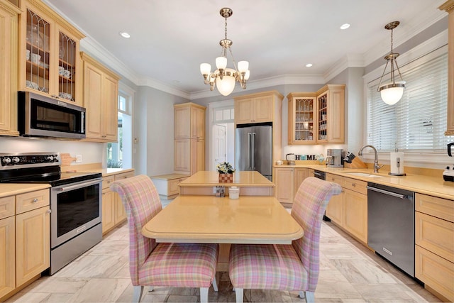 kitchen with appliances with stainless steel finishes, decorative light fixtures, a notable chandelier, and sink