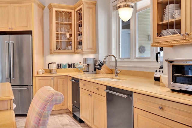 kitchen with appliances with stainless steel finishes, light brown cabinets, a healthy amount of sunlight, and sink