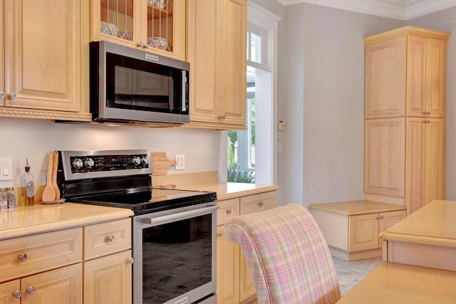 kitchen featuring crown molding, light brown cabinetry, and appliances with stainless steel finishes