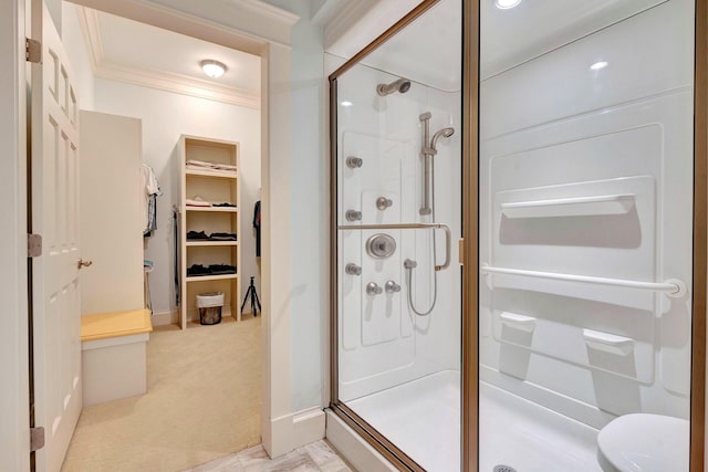 bathroom with a shower with shower door and ornamental molding