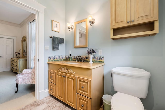 bathroom featuring vanity, toilet, and crown molding