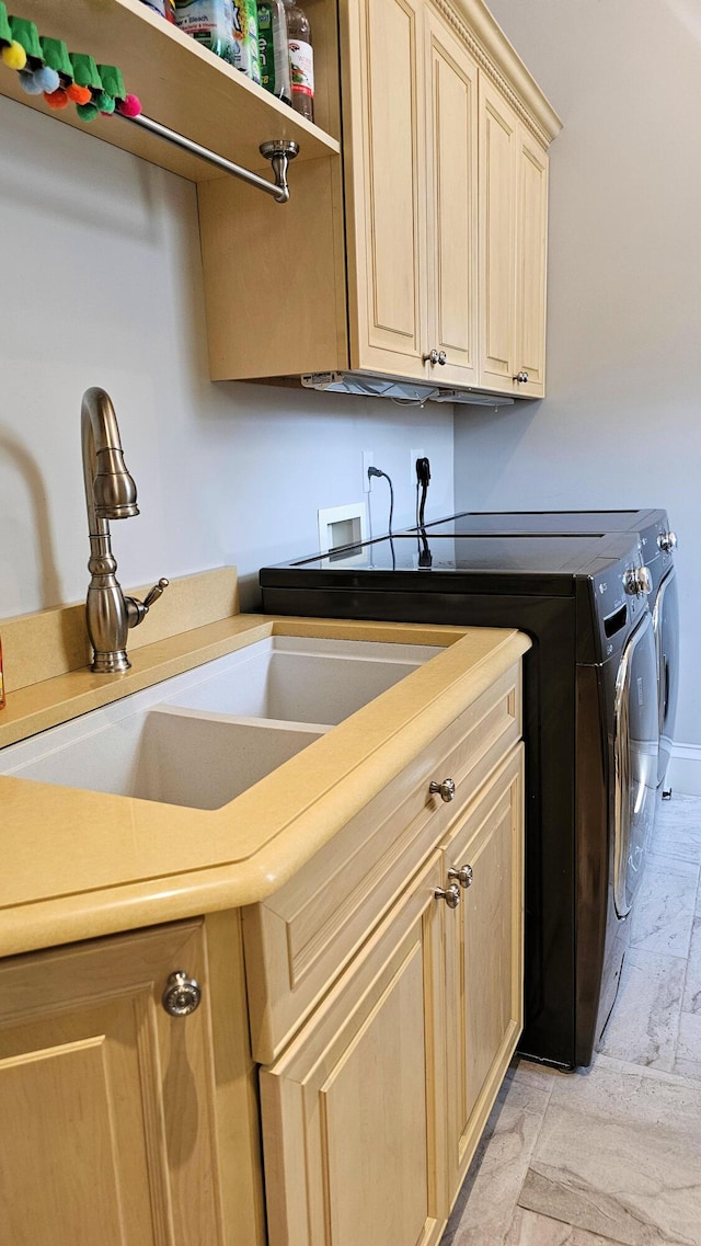 washroom featuring cabinets, light tile patterned floors, washer and clothes dryer, and sink