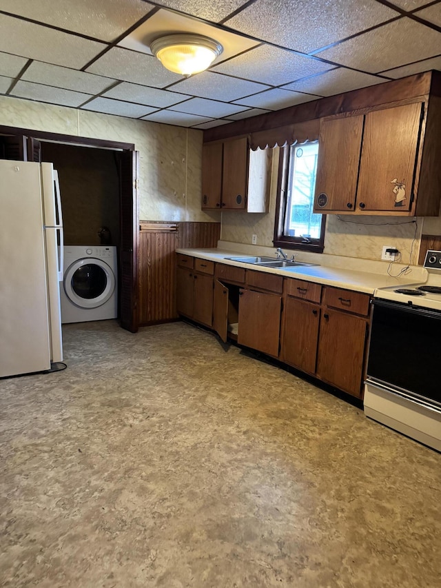 kitchen with washer / clothes dryer, sink, a drop ceiling, and white appliances