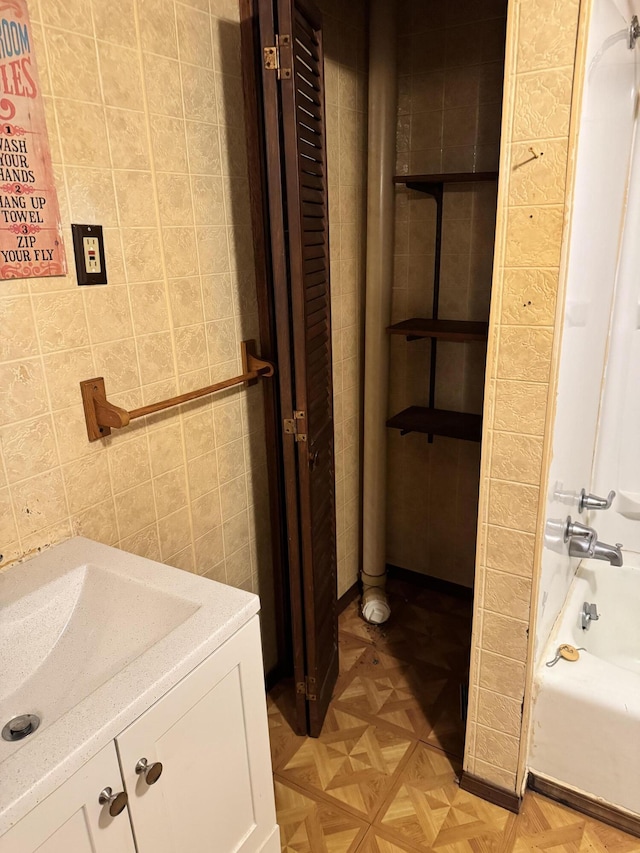 bathroom with vanity, parquet flooring, and tub / shower combination