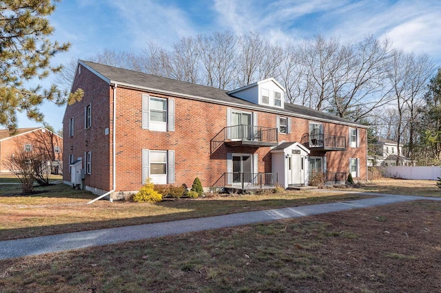 view of property with a front yard and a balcony