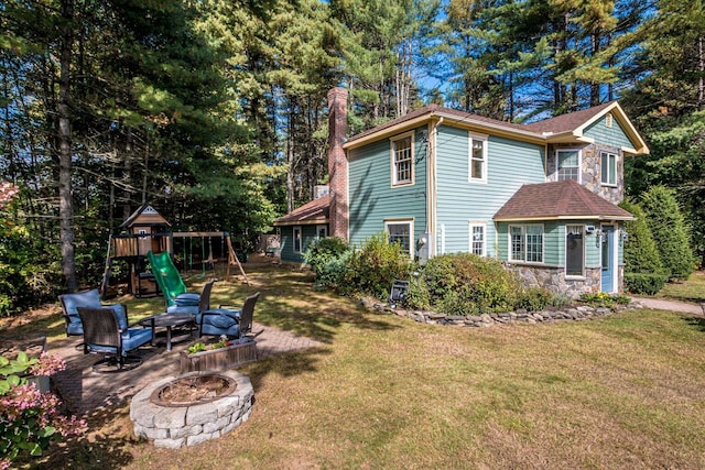 exterior space featuring a yard, a playground, and an outdoor fire pit