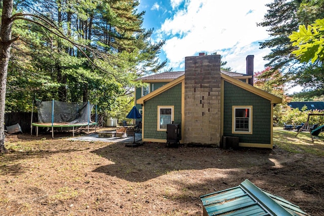 view of side of home with a patio and a trampoline