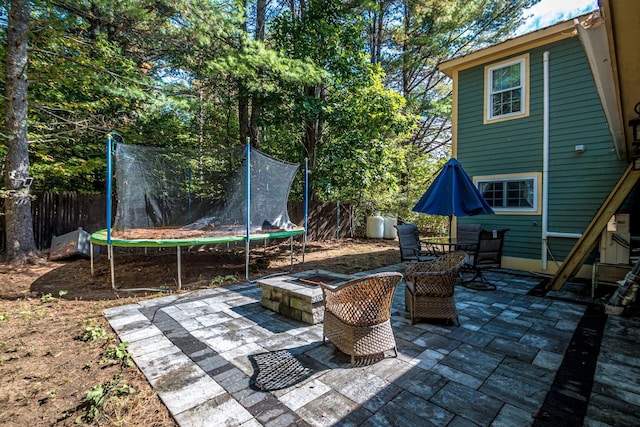 view of patio / terrace with a fire pit and a trampoline