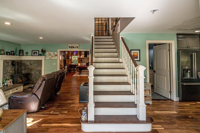 staircase with a wood stove and hardwood / wood-style flooring