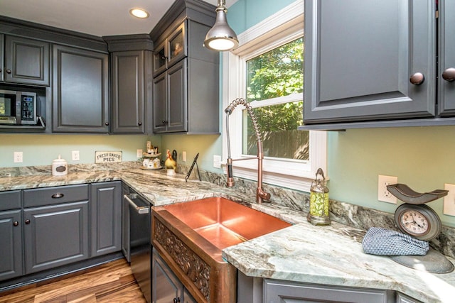 kitchen with gray cabinetry, decorative light fixtures, and light wood-type flooring