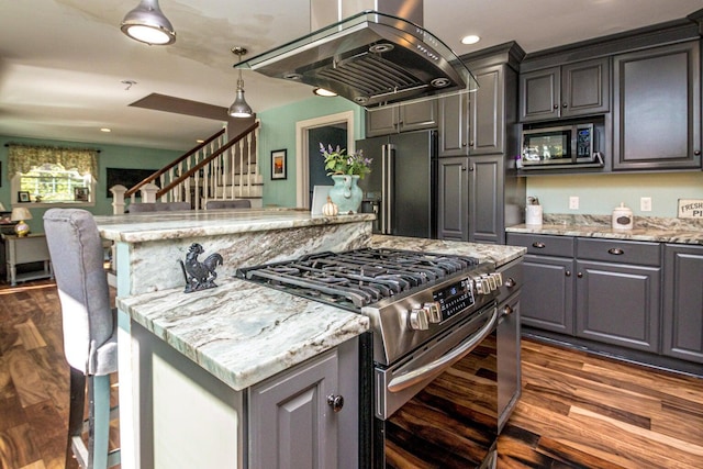 kitchen featuring a center island, gray cabinets, premium appliances, island range hood, and light stone counters