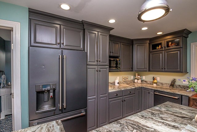 kitchen with light stone countertops and appliances with stainless steel finishes