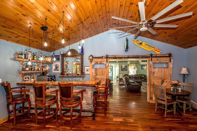 bar with a barn door, dark wood-type flooring, and vaulted ceiling