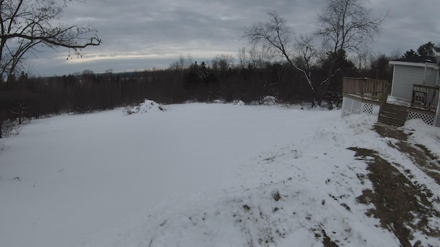 yard covered in snow featuring a wooden deck