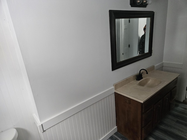 bathroom featuring vanity, wood-type flooring, and toilet