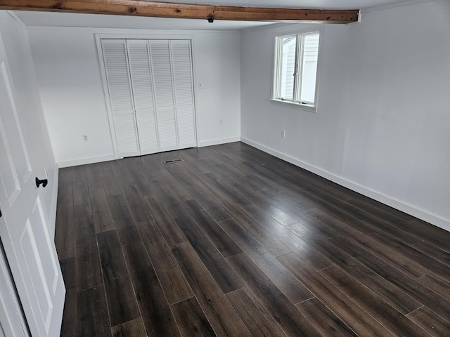 unfurnished bedroom featuring a closet and dark wood-type flooring