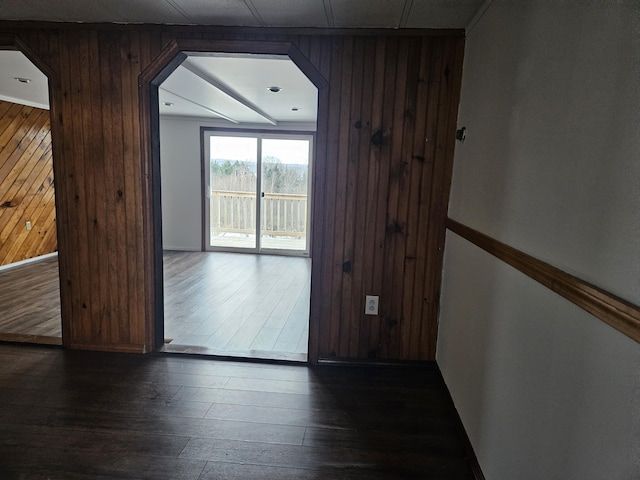 interior space with wooden walls and dark hardwood / wood-style floors