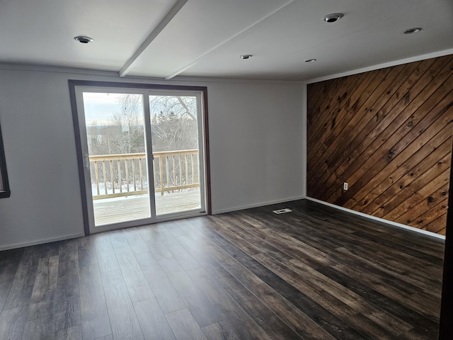 spare room with dark hardwood / wood-style floors and wood walls