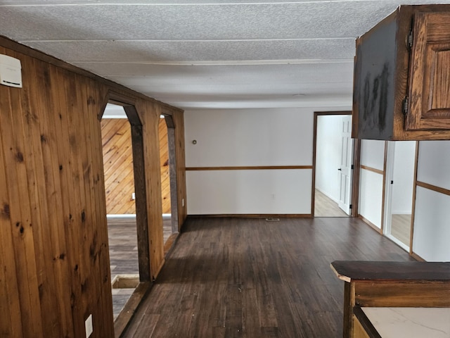 empty room with hardwood / wood-style floors and wood walls