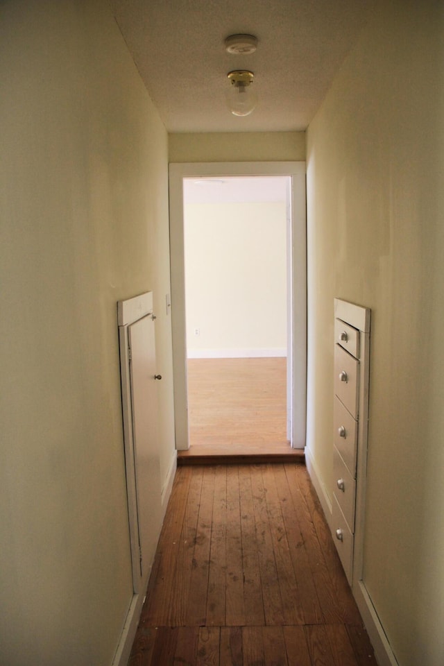 hallway with dark hardwood / wood-style flooring