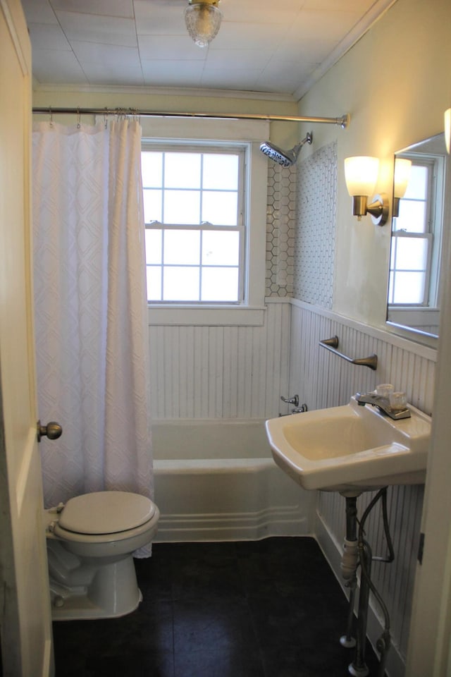 bathroom with toilet, shower / bath combo with shower curtain, and crown molding