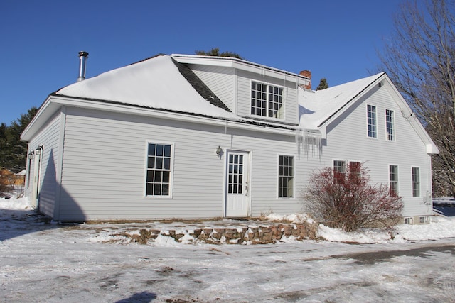 view of snow covered back of property