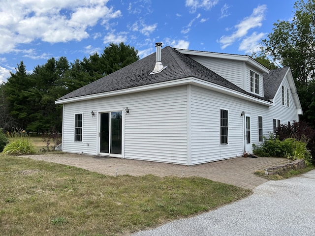 rear view of property with a yard and a patio