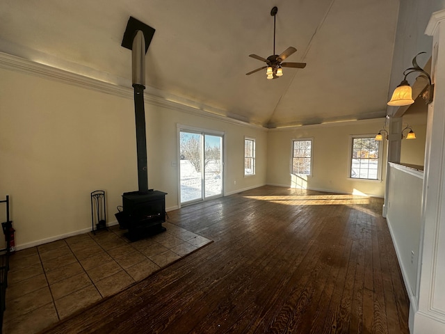 unfurnished living room with ceiling fan, dark hardwood / wood-style floors, a wood stove, and high vaulted ceiling