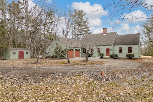 35 Cushman Rd, Nobleboro, ME 04555 - view of front facade featuring dirt driveway, a storage unit, an attached garage, and a chimney