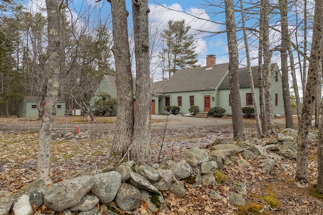 35 Cushman Rd, Nobleboro, ME 04555 - view of front facade featuring concrete driveway, a chimney, a garage, and roof with shingles