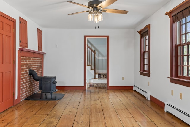 35 Cushman Rd, Nobleboro, ME 04555 - interior space with light wood finished floors, a wood stove, ceiling fan, and a baseboard radiator