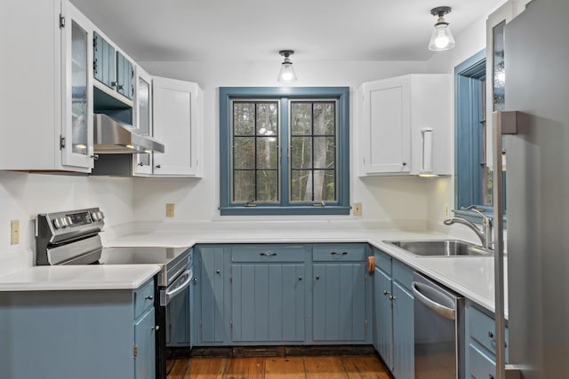 35 Cushman Rd, Nobleboro, ME 04555 - kitchen featuring light countertops, a sink, wall chimney exhaust hood, appliances with stainless steel finishes, and dark wood-type flooring