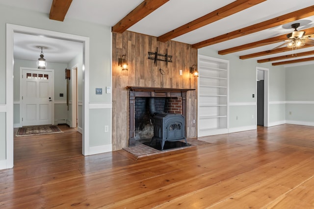 35 Cushman Rd, Nobleboro, ME 04555 - unfurnished living room featuring ceiling fan, built in shelves, baseboard heating, a wood stove, and wood-type flooring