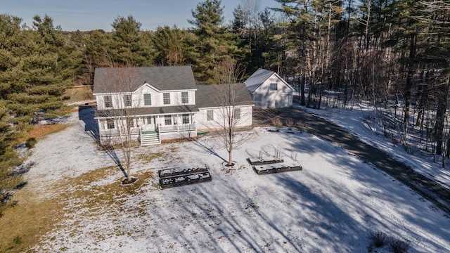 snow covered back of property with a porch