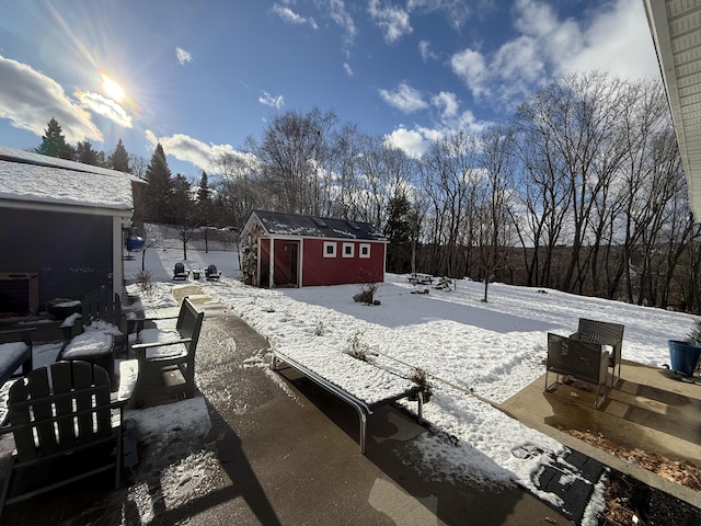 snowy yard featuring a shed