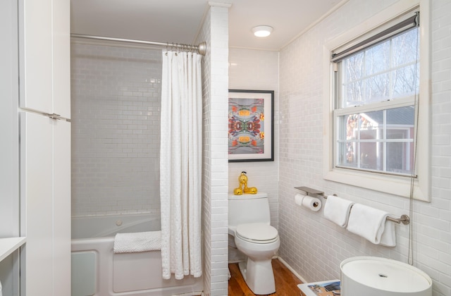 bathroom featuring toilet, wood-type flooring, ornamental molding, and shower / bath combo with shower curtain