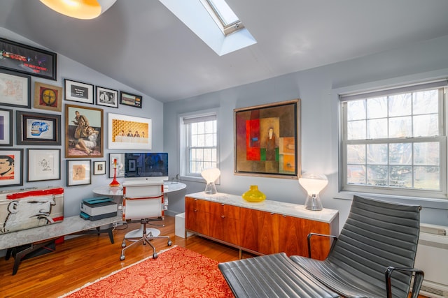 living area with hardwood / wood-style floors and lofted ceiling with skylight