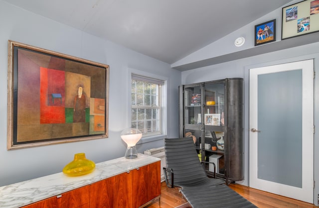 sitting room with light hardwood / wood-style floors and vaulted ceiling