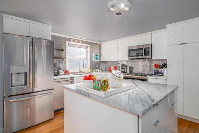 kitchen featuring white cabinetry, appliances with stainless steel finishes, a center island, and sink