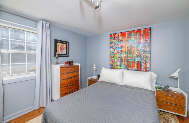 bedroom with multiple windows and light hardwood / wood-style floors