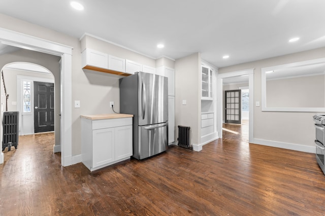 kitchen featuring stainless steel fridge, dark hardwood / wood-style flooring, white cabinetry, and built in shelves