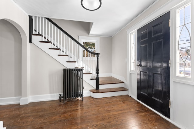 foyer featuring radiator heating unit, dark hardwood / wood-style floors, and crown molding