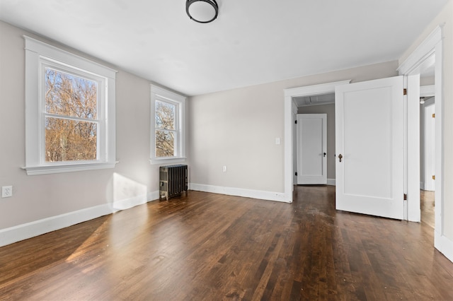 unfurnished living room with dark wood-type flooring and radiator