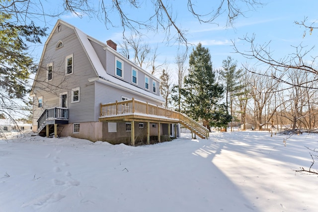 snow covered house featuring a deck