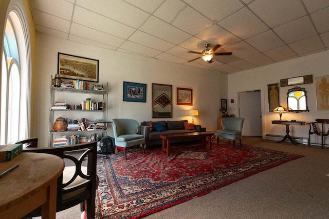 living room featuring a paneled ceiling, ceiling fan, and carpet