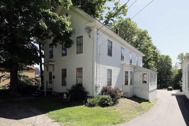 view of side of home with a yard