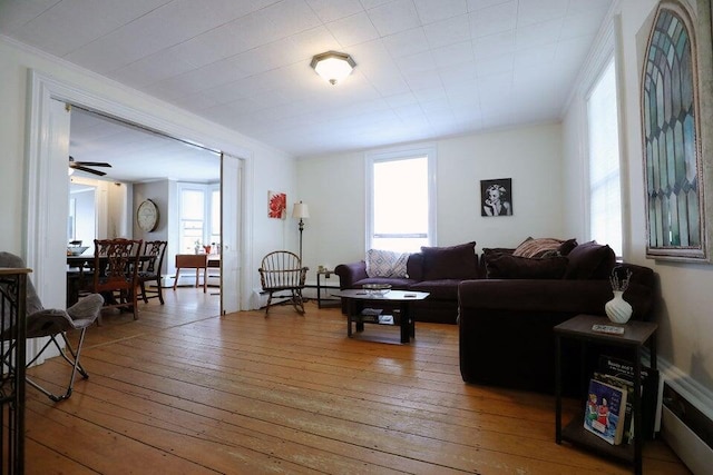 living room featuring ceiling fan, ornamental molding, and hardwood / wood-style flooring